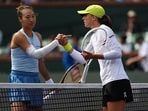Iga Swiatek (R) shakes hands with Qinwen Zheng (L).