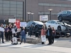 People participate in a protest against Elon Musk outside of a Tesla dealership in West Bloomfield, Michigan on March 13, 2025.