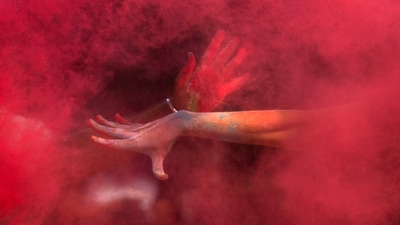 A girl throws colored powder on her friend as they celebrate Holi, the Hindu festival of colors, in Mumbai, India, Friday, March 14, 2025. (AP)