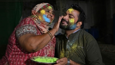 A mother paints the face of her son as they celebrate Hindu festival of Holi in Tharparkar district of the desert town of Mithi, south-eastern Pakistan, on March 13, 2025. (AFP)