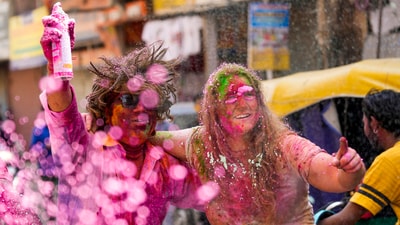 Foreign tourists participate in Holi celebrations along with locals in Paharganj, in New Delhi. (PTI)
