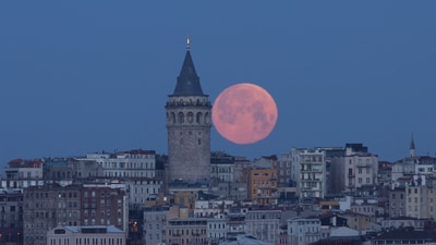 The moon is seen behind the Galata Tower in Istanbul, Turkey, March 14, 2025. (REUTERS)