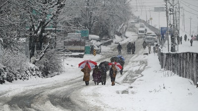 People walk during snowfall at Gund village of district Ganderbal,some 75 kms from Srinagar on 15 March 2025. ((Photo By Waseem Andrabi /Hindustan Times))