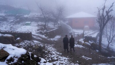 Local men walk on a road after mild snowfall on the outskirts of Srinagar, Saturday, March 15, 2025. (PTI) Local men walk on a road after mild snowfall on the outskirts of Srinagar, Saturday, March 15, 2025. (PTI)
