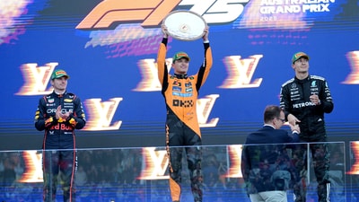 McLaren's Lando Norris celebrates with the trophy on the podium after winning the Australian Grand Prix (REUTERS)