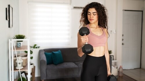 Dumbbell bicep curls are one exercise that can help you get rid of flabby arms, per the fitness coach. (Shutterstock)