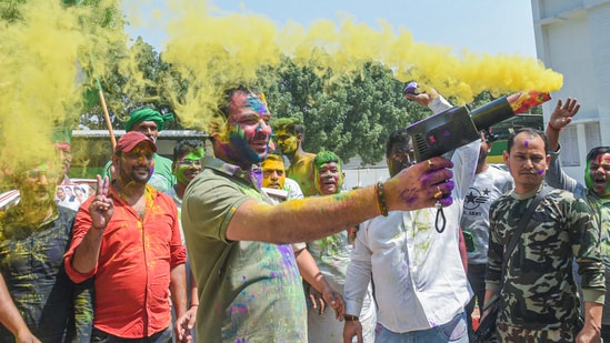 Rashtriya Janata Dal (RJD) MLA Tej Pratap shoots hues in the air while celebrating Holi with party workers at his residence, in Patna on Saturday. (ANI Photo) (Pappi Sharma )