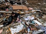 Several violent tornadoes have been ripping through the US, leading to at least 40 fatalities after a storm system rapidly progressed across the country since Friday. In pic: One person was seen searching through the wreckage of her home inside of her trailer park, after the devastation caused by the storms