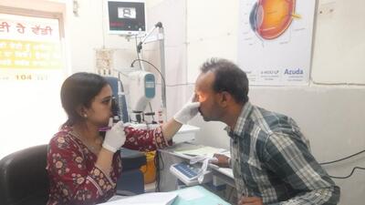 A doctor examining a patient, who experienced redness and pain in the eyes after applying an oil provided at a free hair treatment camp in Sangrur on Monday. (HT Photo)