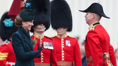 TOPSHOT - Britain's Catherine, Princess of Wales (L) reacts after receiving a traditional sprig of shamrock, as she attends St Patrick's Day Parade at Wellington Barracks, central London, on March 17, 2025. (Photo by Adrian DENNIS / AFP) (AFP)