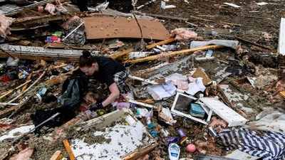 Several violent tornadoes have been ripping through the US, leading to at least 40 fatalities after a storm system rapidly progressed across the country since Friday. In pic: One person was seen searching through the wreckage of her home inside of her trailer park, after the devastation caused by the storms (AFP) Several violent tornadoes have been ripping through the US, leading to at least 40 fatalities after a storm system rapidly progressed across the country since Friday. In pic: One person was seen searching through the wreckage of her home inside of her trailer park, after the devastation caused by the storms (AFP)