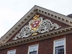 CAMBRIDGE, MASSACHUSETTS - MARCH 17: The Veritas shield with wreath and banner on Stone House at Harvard University on March 17, 2025 in Cambridge, Massachusetts. 