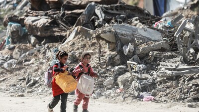 Palestinian children walk past rubble as people make their way to flee their homes, after the Israel army issued evacuation orders for a number of neighborhoods, following heavy Israeli strikes, in Beit Lahiya. (REUTERS)