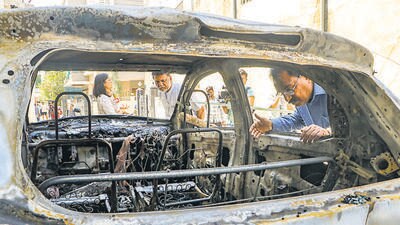 Nagpur: People stand near charred remains of a car at Chitnis Park area amid curfew after violence erupted on Monday night, in Nagpur, early Tuesday, March 18, 2025. Curfew has been imposed in several areas of Maharashtra's Nagpur city after a protest against Mughal emperor Aurangzeb's tomb triggered violence here during which several houses and vehicles were vandalised, officials said on Tuesday. (PTI Photo) (PTI03_18_2025_000065B) (PTI) Nagpur: People stand near charred remains of a car at Chitnis Park area amid curfew after violence erupted on Monday night, in Nagpur, early Tuesday, March 18, 2025. Curfew has been imposed in several areas of Maharashtra's Nagpur city after a protest against Mughal emperor Aurangzeb's tomb triggered violence here during which several houses and vehicles were vandalised, officials said on Tuesday. (PTI Photo) (PTI03_18_2025_000065B) (PTI)