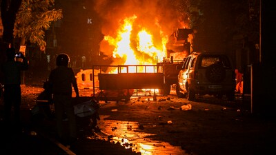 Nagpur violence: Police personnel near charred remains of a vehicle, a day after violence broke out following an agitation by a right-wing group demanding the removal of Aurangzeb's tomb. (PTI) Nagpur violence: Police personnel near charred remains of a vehicle, a day after violence broke out following an agitation by a right-wing group demanding the removal of Aurangzeb's tomb. (PTI)