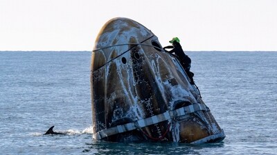 A support team member works on the SpaceX capsule shortly after it landed with NASA astronauts Nick Hague, Sunita Williams, Butch Wilmore, and Russia's Alexander Gorbunov aboard as a dolphin swims past in the water off the coast of Tallahassee, Florida, on Tuesday, March 18, 2025. (AP) A support team member works on the SpaceX capsule shortly after it landed with NASA astronauts Nick Hague, Sunita Williams, Butch Wilmore, and Russia's Alexander Gorbunov aboard as a dolphin swims past in the water off the coast of Tallahassee, Florida, on Tuesday, March 18, 2025. (AP)