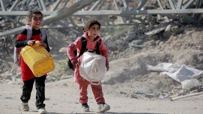 Palestinian girls carry empty jerrycans and their few belongings in backpacks as they join people leaving the eastern sector of the Gaza Strip. (AFP) Palestinian girls carry empty jerrycans and their few belongings in backpacks as they join people leaving the eastern sector of the Gaza Strip. (AFP)