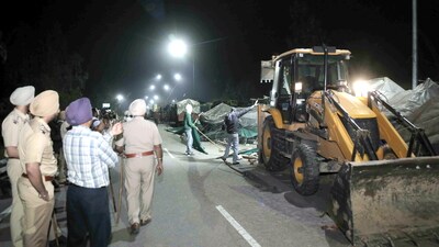 A backhoe loader being used to dismantle temporary structures set up by agitating farmers during an eviction drive by the Punjab Police to remove them from the Shambhu border, in Patiala district, Wednesday night, March 19, 2025. (PTI)