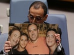 Eli Sharabi, a former Israeli hostage released by Hamas in Gaza last month, holds of a photograph of his wife and two daughters killed by Hamas, as he addresses a meeting of the United Nations Security Council at the UN headquarters in New York City.