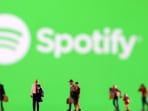 Small figurines are seen in front of displayed Spotify logo in this illustration taken February 11, 2022.