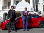 US President Donald Trump talks to the media next to Tesla CEO Elon Musk.