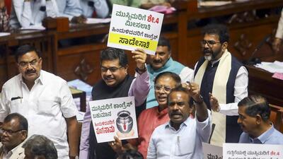BJP and JDS members hold placards in protest demanding a judicial probe by a sitting High Court judge into the alleged ‘honey-trap’ attempt involving a minister and other politicians, during the Budget session of Karnataka Assembly, in Bengaluru, on Friday (PTI)