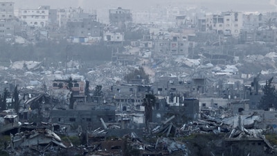 People walk among destroyed buildings in Gaza, as viewed from the Israel-Gaza border, March 20, 2025. (REUTERS)