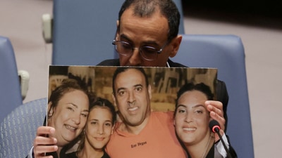 Eli Sharabi, a former Israeli hostage released by Hamas in Gaza last month, holds of a photograph of his wife and two daughters killed by Hamas, as he addresses a meeting of the United Nations Security Council at the UN headquarters in New York City. (REUTERS)