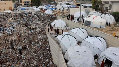 Displaced Palestinians stand outside tents set up at a landfil in the Yarmuk area in Gaza City on March 20, 2025. (AFP) Displaced Palestinians stand outside tents set up at a landfil in the Yarmuk area in Gaza City on March 20, 2025. (AFP)