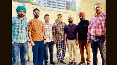 The accused (face covered) in Vigilance Bureau custody in Ludhiana on Friday. (HT Photo)