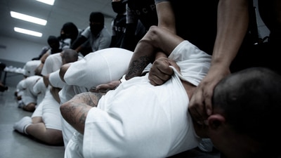 Salvadoran police officers escort alleged members of the Venezuelan gang deported by the US government. (via REUTERS)