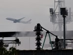 A plane takes off, as smoke rises from an area of an electrical substation a day after it caught fire and wiped out power at Heathrow International Airport, near London, Britain, March 22, 2025. REUTERS/Carlos Jasso
