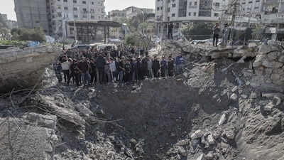 Palestinians inspect the site of an Israeli airstrike on a camp housing displaced people in Gaza City, on Sunday, March 23, 2025. (Bloomberg) Palestinians inspect the site of an Israeli airstrike on a camp housing displaced people in Gaza City, on Sunday, March 23, 2025. (Bloomberg)