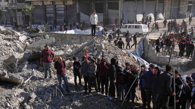 Behind a tent camp for displaced Palestinians, smoke rises from a building after it was targeted by an Israeli army strike, following evacuation orders for residents, in Gaza City. (AP) Behind a tent camp for displaced Palestinians, smoke rises from a building after it was targeted by an Israeli army strike, following evacuation orders for residents, in Gaza City. (AP)