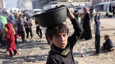 A boy walks with a pot of food he received after queueing for charity meals given out during the Muslim holy fasting month of Ramadan, in Gaza City. (AFP) A boy walks with a pot of food he received after queueing for charity meals given out during the Muslim holy fasting month of Ramadan, in Gaza City. (AFP)