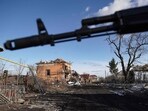 Russian soldiers walk past destroyed houses in the village of Kazachya Loknya in the Sudzha district of the Kursk region on March 18, 2025,