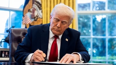 US President Donald Trump signs an executive order in the Oval Office of the White House in Washington, DC, US, on Wednesday, March 26, 2025. (Bloomberg)