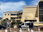 People walk next to an Egyptian police vehicle in front of the hospital where the bodies of foreigners who were killed when a tourist submarine sank off Egypt's Red Sea resort city of Hurghada are kept in Hurghada, Egypt, March 27, 2025.