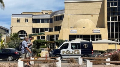 People walk next to an Egyptian police vehicle in front of the hospital where the bodies of foreigners who were killed when a tourist submarine sank off Egypt's Red Sea resort city of Hurghada are kept in Hurghada, Egypt, March 27, 2025. (Reuters)