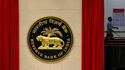 A worker walks past the logo of Reserve Bank of India (RBI) inside its office in New Delhi, India. (Reuters)