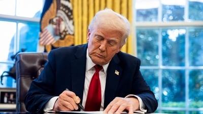 US President Donald Trump signs an executive order in the Oval Office of the White House in Washington, DC, US, on March 26.  Trump said he will be implementing a 25% tariff on auto imports, expanding a trade war. (Bloomberg)