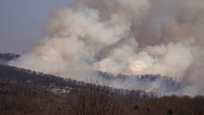 PUMPKINTOWN, SOUTH CAROLINA - MARCH 26: Smoke rises from the Table Rock Complex fire as seen from Sassafras Mountain on March 26, 2025 in Pumpkintown, South Carolina. Drought-like conditions and high winds are fueling multiple wildfires that have triggered evacuations across northern South Carolina (Photo by Sean Rayford / GETTY IMAGES NORTH AMERICA / Getty Images via AFP) (Getty Images via AFP) PUMPKINTOWN, SOUTH CAROLINA - MARCH 26: Smoke rises from the Table Rock Complex fire as seen from Sassafras Mountain on March 26, 2025 in Pumpkintown, South Carolina. Drought-like conditions and high winds are fueling multiple wildfires that have triggered evacuations across northern South Carolina (Photo by Sean Rayford / GETTY IMAGES NORTH AMERICA / Getty Images via AFP) (Getty Images via AFP)