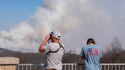 PUMPKINTOWN, SOUTH CAROLINA - MARCH 26: People watch as smoke rises from the Table Rock Complex fire as seen from Sassafras Mountain on March 26, 2025 in Pumpkintown, South Carolina. Drought-like conditions and high winds are fueling multiple wildfires that have triggered evacuations across northern South Carolina. (Photo by Sean Rayford / GETTY IMAGES NORTH AMERICA / Getty Images via AFP) (Getty Images via AFP) PUMPKINTOWN, SOUTH CAROLINA - MARCH 26: People watch as smoke rises from the Table Rock Complex fire as seen from Sassafras Mountain on March 26, 2025 in Pumpkintown, South Carolina. Drought-like conditions and high winds are fueling multiple wildfires that have triggered evacuations across northern South Carolina. (Photo by Sean Rayford / GETTY IMAGES NORTH AMERICA / Getty Images via AFP) (Getty Images via AFP)