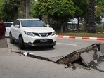 A car attempts to drive along a damaged road in Naypyidaw on March 28, 2025, after an earthquake in central Myanmar. 
