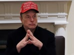Tesla CEO Elon Musk wears a 'Trump Was Right About Everything!' hat while 