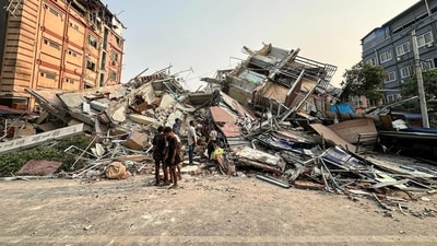 People stand past the debris of a collapsed building in Mandalay in Myanmar, on March 28, 2025, after an earthquake. (AFP) People stand past the debris of a collapsed building in Mandalay in Myanmar, on March 28, 2025, after an earthquake. (AFP)