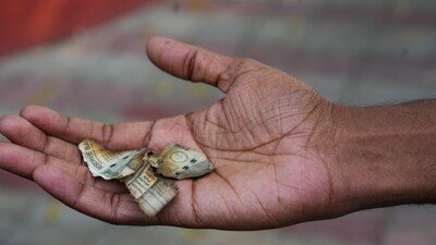 A man shows burnt pieces of a currency note found among debris near the residence of Delhi High Court judge Justice Yashwant Varma, in New Delhi (PTI) A man shows burnt pieces of a currency note found among debris near the residence of Delhi High Court judge Justice Yashwant Varma, in New Delhi (PTI)