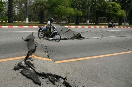 A motorcyclist rides past a damaged road in Naypyidaw on March 28, 2025, after an earthquake in central Myanmar. (AFP) A motorcyclist rides past a damaged road in Naypyidaw on March 28, 2025, after an earthquake in central Myanmar. (AFP)