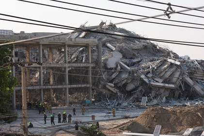 Rescue personnel stand near a building that collapsed after a strong earthquake struck central Myanmar on Friday, earthquake monitoring services said, which affected Bangkok as well. (REUTERS)
