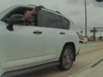 A driver in a grey Lexus pointing a firearm at a Tesla Cybertruck. A driver in a grey Lexus pointing a firearm at a Tesla Cybertruck.